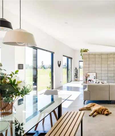  ??  ?? LIVING Natural light streams into the open-plan kitchen, living and dining space, where generous sliding doors allow fresh air to circulate freely throughout the spacious home.