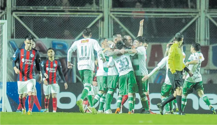  ?? JUANO TESONE ?? El golpe. Los jugadores de Temuco “ocultan” a Riquero, quien acaba de meter el segundo gol. San Lorenzo deberá ganar por dos goles de visitante para pasar directo.