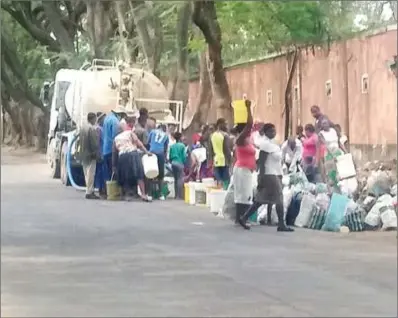  ??  ?? Bulawayo Municipal Compound residents jostle for water at a council bowser at the weekend in Makokoba