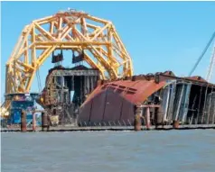  ?? AP FILE PHOTO/RUSS BYNUM ?? In April, a towering crane pulls the engine room section away from the remains of the capsized cargo ship Golden Ray off St. Simons Island, Ga.