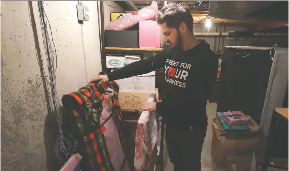  ?? CHARLES REX ARBOGAST/AP PHOTO, FILE ?? Former NHL player Dan Carcillo looks through some of his memorabili­a, which is wrapped up in the basement of his rural home in Homer Glen, Ill.