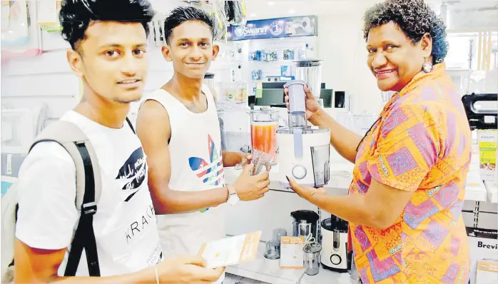  ?? Picture: ATU RASEA ?? Customers Ariszy Shimeel Singh left, Ashwan James Sagar check out the juice makers available at Courts Rodwell Rd with staff member Raijeli Rokomaqisa.