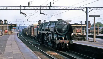  ?? COLOUR RAIL PETER WALTON ?? Willesden-allocated No. 70014 Iron Duke saunters through Watford Junction with a Down freight circa 1964. The locomotive still retains the drilled holes in the smoke deflectors for the small arrows carried during its ‘Golden Arrow’ heyday at Stewarts...