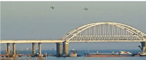  ?? FOTO: AFP ?? Die von einem russischen Schiff blockierte Meerenge von Kertsch mit der neuen Brücke, darüber zwei russische Flugzeuge.