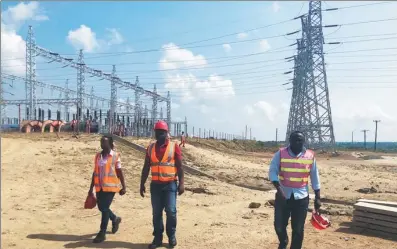  ?? PHOTOS BY XIAO XIANGYI / CHINA DAILY ?? Ugandan employees of China Internatio­nal Water &amp; Electric Corp in front of the switchyard of Isimba hydropower station. The project site is about 21km from Kayunga Town.