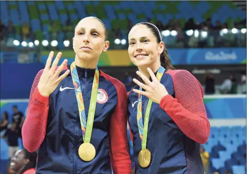  ?? Andrej Isakovic / TNS ?? Team USA’s Diana Taurasi, left, and Sue Bird pose with their gold medals after the women’s basketball final during the 2016 Summer Olympics in Rio de Janeiro.