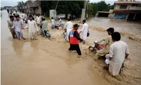  ?? Agency/Getty Images ?? Displaced people wade through a flooded area in Peshawar, Pakistan. The country’s flooded southern Sindh province braced on Sunday for a fresh deluge. Photograph: Anadolu