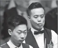  ?? XINHUA ?? China’s Lyu Haotian (left) and compatriot Marco Fu study the table during their first-round match at the World Championsh­ip in Sheffield on Sunday. Lyu notched a 10-5 victory.