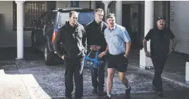  ??  ?? LUCKY ESCAPE. Bruce Botha, left, Wayne Stuart, centre, and members of the family waiting for a getaway bakkie at Belfast Magistrate’s Court.