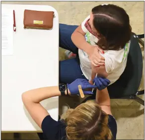  ?? (Arkansas Democrat-Gazette/Staci Vandagriff) ?? Whitney Campbell, a pharmacist for Express Rx at Otter Creek, gives Adrienne Dallas of Little Rock her second dose of the Pfizer vaccine Thursday at Henderson United Methodist Church in Little Rock.