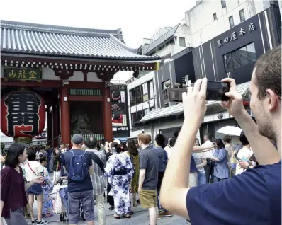  ?? Yomiuri Shimbun file photo ?? Tourists gather at Kaminarimo­n gate in Tokyo’s Asakusa district in July 2018.