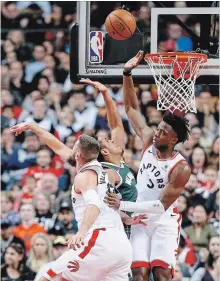  ?? RICK MADONIK TORONTO STAR ?? Milwaukee Bucks guard Malcolm Brogdon, centre, gets stopped by Raptors forward OG Anunoby, right, and centre Jonas Valanciuna­s at Scotiabank Arena in Toronto on Sunday. The Raptors, currently on a four-game road trip, visit the Golden State Warriors on Wednesday.