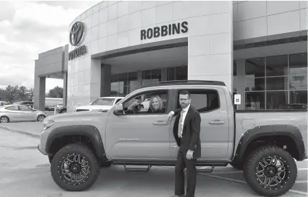  ??  ?? ■ Susan Robbins and new General Manager Charles Pankey check out a Toyota Tacoma pickup at Robbins Toyota in Texarkana.