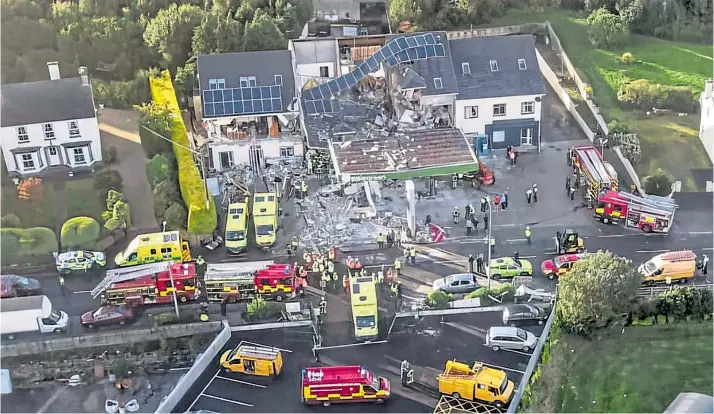  ?? ?? Police, fire service and ambulances at the scene yesterday after a huge explosion destroyed a petrol station in Creeslough, Donegal