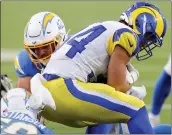  ?? ?? Chargers linebacker Troy Reeder, back, stops Rams running back Jake Funk after a short gain in the first half of the exhibition opener Saturday night at Sofi Stadium.