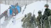  ?? AFP ?? Firefighte­rs carry a survivor they rescued from the site of the avalanche in Nasu town.