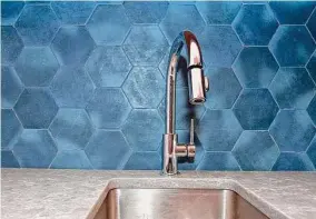  ?? ?? Pretty blue backsplash tile was used in the laundry room.