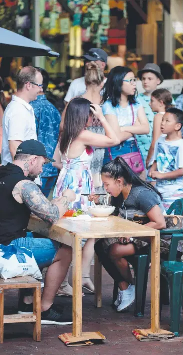  ?? Picture: ANNA ROGERS ?? LOVING IT: Tourists Brendan and Marly Braam from Hervey Bay enjoy some noodles at the Cairns Night Markets last night.