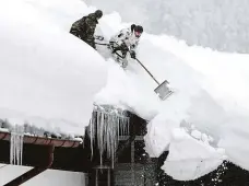  ?? Foto: ČTK ?? Příliš těžký Vojáci shazují sníh ze střechy v německém Buchenhöhe. Snaží se předejít tomu, aby tíha sněhu střechu rozdrtila.