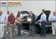  ??  ?? Mark Dolinski, vice president of membership and events of the Greater Reading Chamber Alliance, presents a certificat­e to Kendra Cook and Bob Dare of the Boyertown Museum of Historic Vehicles. The museum has added six electric vehicle charging stations to the facility.