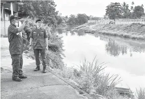  ?? — Gambar Bernama ?? INGIN TAHU: Mohd Ridzuan (kanan) mendengar penerangan daripada Rusli (kiri) ketika meninjau pangkalan haram sempadan Malaysia-Thailand Sungai Golok berdekatan pekan Rantau Panjang, Pasir Mas semalam.