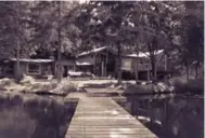  ??  ?? The cottage in summer, with its dock extending into the one-acre pond on the site.