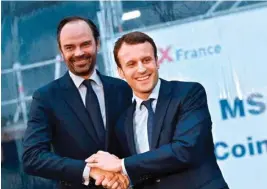  ??  ?? A photo from 2016 shows Emmanuel Macron (right) shaking hands with Édouard Philippe