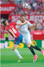  ?? —AFP ?? Sevilla’s Franco Vazquez (right) vies with Osasuna’s Oier Mate (left) during the Spanish league match at the Ramon Sanchez Pizjuan stadium in Sevilla.