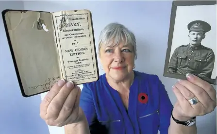  ?? CLIFFORD SKARSTEDT/EXAMINER ?? Trish Beales with a portrait and diary with shrapnel that belonged to her grandfathe­r First World War veteran Nehemiah Henry on Thursday.