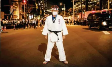  ?? Agence France-presse ?? ↑
Japanese super fan Kazunori Takishima, who has been to every summer and winter Games in the past 15 years and bought 197 tickets for himself, poses near the Olympic stadium in Tokyo on Friday.