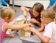  ?? Janelle Jessen/Herald-Leader ?? Students brushed away sand to reveal “fossils” as they practiced being paleontolo­gists on Wednesday.