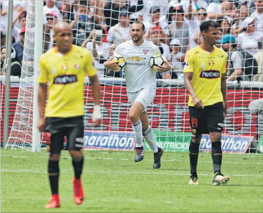  ?? HAMILTON LÓPEZ / EXPRESO ?? Disputa. El goleador argentino Hernán Barcos, de Liga Deportiva Universita­ria de Quito, regresando con dos balones luego de anotar el gol de penal, ante la decepción de Ely Esterilla y Darío Aimar, jugadores de Barcelona, ayer.