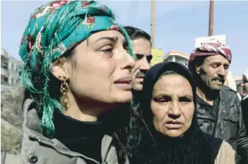  ?? — AFP ?? The mother (C) and sister (L) of the late 23-year-old YPJ fighter Barin Kobani, attending a mourning ceremony in her honour, after the YPJ and the Syrian Observator­y for Human Rights accused Turkish-backed Syrian rebels of filming her mutilated dead...