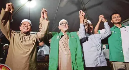  ?? PIC BY ADZLAN SIDEK ?? Pas president Datuk Seri Abdul Hadi Awang (second from left) campaignin­g for the party’s candidate for the Port Dickson by-election, Lieutenant Colonel (Rtd) Mohd Nazari Mokhtar (left), in Teluk Kemang on Sunday.