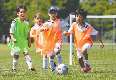  ?? ERROL MCGIHON ?? Children get some fresh air and some exercise at a summer soccer camp and tournament Friday at Greenboro field that was organized by the U.S.-based Real Madrid Foundation. Kids playing is a sign of returning to normalcy, writes Mohammed Adam.