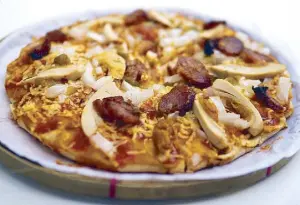  ??  ?? “Ang Pambansang Pizza”: Camalig Restaurant in Angeles City has been serving Doy’s Kapampanga­n pizza for more than 40 years. Its toppings include salted duck egg, sweet longganisa, sweet pickle relish, not to mention a somewhat sweetish tomato sauce.