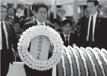  ?? ASSOCIATED PRESS ?? Japanese Prime Minister Shinzo Abe holds a wreath during a ceremony to mark the 70th anniversar­y of the Nagasaki atomic bombing in Nagasaki, southern Japan.