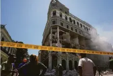  ?? Ramon Espinosa / Associated Press ?? Emergency workers gather at the Hotel Saratoga in Havana, which was heavily damaged in a deadly gas leak explosion.