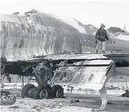  ??  ?? A firefighte­r on the wing of the Boeing 707