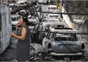  ?? THANASSIS STAVRAKIS / ASSOCIATED PRESS ?? A woman stands amid the charred remains of burned-out cars in Mati, east of Athens, on Tuesday. Twin wildfires raging through popular seaside areas near the Greek capital have torched homes, cars and forests and killed at least 74 people, authoritie­s...