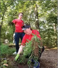  ?? NWA Democrat-Gazette/FLIP PUTTHOFF ?? Nicholas Pleiman, 14, and his mom, Jennifer Pleiman, members of the Young Men’s Service League, clear weeds Saturday at Restoratio­n Village in Little Flock.