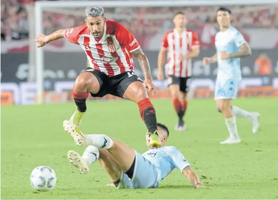  ?? FOTOBAIRES ?? Luchado. Eros Mancuso salta y pasa el cruce de un defensor de Racing. Un duro duelo en La Plata donde sólo faltaron los goles.