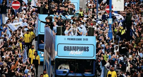  ?? ?? Elation: Fans line the streets (main) as City stars Dias and Silva (below left) show off the Premier League trophy. Grealish and De Bruyne get into the party spirit while (right) boss Pep Guardiola enjoys a cigar