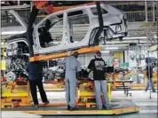  ?? Reuters Archive ?? Chrysler assembly workers lower a frame onto a chassis at the Jefferson auto plant in Detroit.