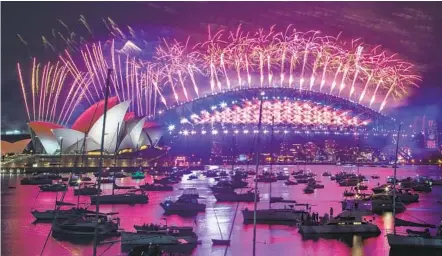  ?? MARK BAKER AP ?? Fireworks explode over the Sydney Opera House and Harbor Bridge as New Year celebratio­ns begin in Sydney, Australia, Thursday.