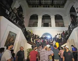  ?? ERANGA JAYAWARDEN­A — THE ASSOCIATED PRESS ?? Protesters storm the residence of Sri Lankan's president in Colombo, Sri Lanka, on Saturday. Protesters also broke into the prime minister's private home, setting it on fire.