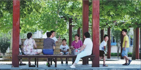  ?? LI RAN / XINHUA ?? Grandparen­ts and children relax at a pavilion in Tianjin. China’s average household size is below the “three-person-family” benchmark.