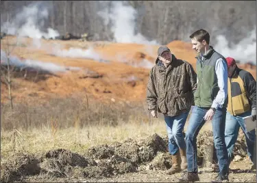  ?? NWA Democrat-Gazette/BEN GOFF • @NWABENGOFF ?? Kevin White (left), associate director of land resources with the Arkansas Department of Environmen­tal Quality, leads U.S. Sen. Tom Cotton and other guests on a tour Friday at the stump dump fire site in Bella Vista.