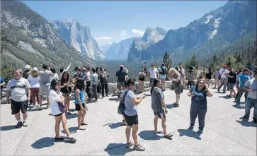  ?? Brian van der Brug Los Angeles Times ?? CROWDS take in Yosemite National Park’s Tunnel View in July. The park drew more than 5 million visitors last year, a 21% increase from the 2015 record. “Even winter is busy,” an organizer of trips to the park says.