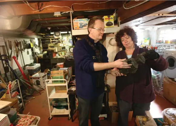  ?? VINCE TALOTTA/TORONTO STAR PHOTOS ?? Sara Young and Craig Rennie, project managers at Transition­Squad, hold an old CPR railway lantern for sale in the basement of the Adams estate. The group specialize­s in tabulating and pricing a home’s contents and then staging an estate sale. The home...